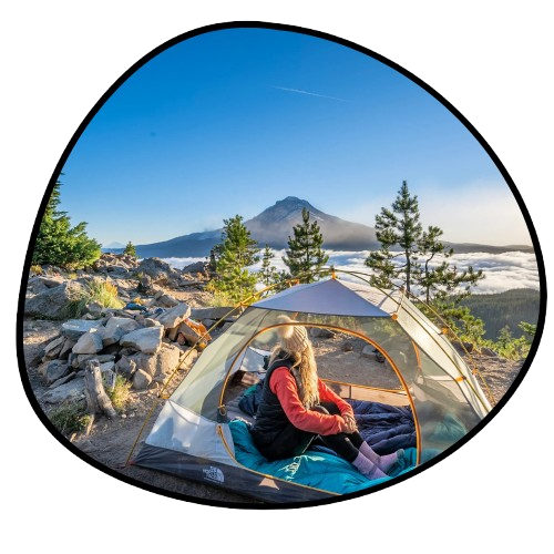 Person sitting inside a tent with a scenic mountain view

